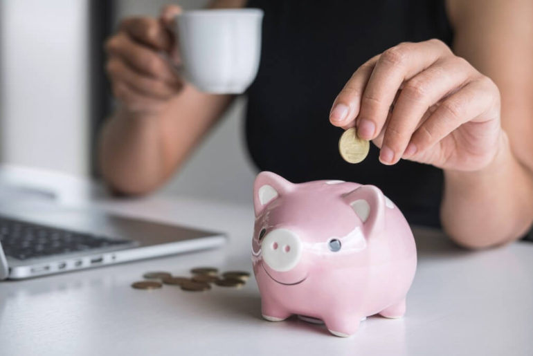 woman putting money in piggy bank for marketing budget